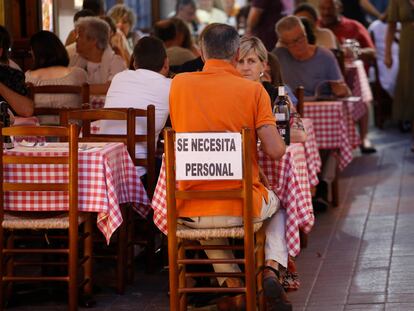 Cartel de "Se necesita personal" en la terraza de un restaurante en Tossa de Mar (Girona).