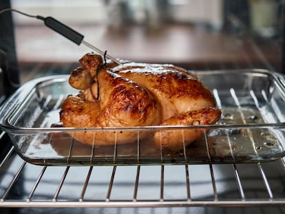 Pollo asado con un termómetro que está midiendo su temperatura interna.