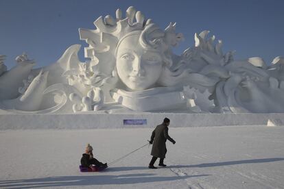 Un hombre y su hija juegan junto a una escultura de nieve de 31 metros de alto.