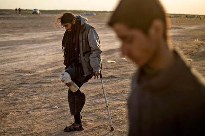 Um homem ferido, suspeito de pertencer ao Estado Islâmico, chega com a ajuda de muletas em um posto de controle das Forças Democráticas da Síria, fora de Baghuz. As forças anti-jihadistas apoiadas por uma coalizão internacional bombardearam intensamente a cidade dois dias antes. As poucas partidas dos últimos dias levaram as Forças Democráticas da Síria a retomar suas operações militares na noite de domingo.