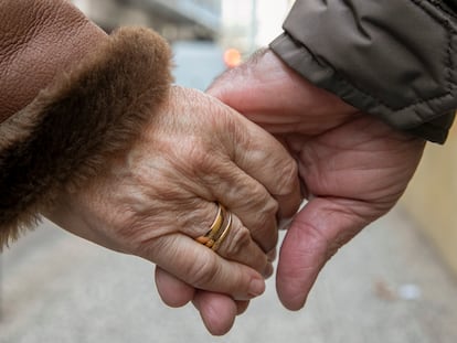 Una pareja camina de la mano por una calle de Zaragoza el día de San Valentín.