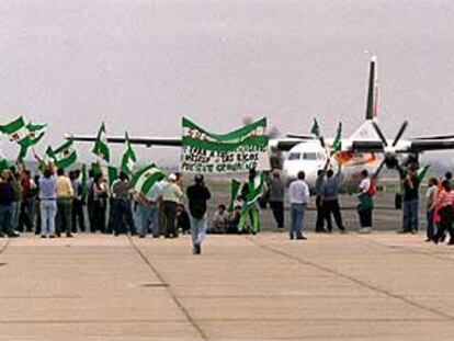 Jornaleros del SOC, ayer en la pista del aeropuerto de Sevilla.