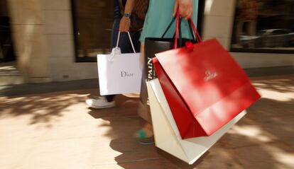 Dos turistas con bolsas de marcas de lujo en Madrid. 