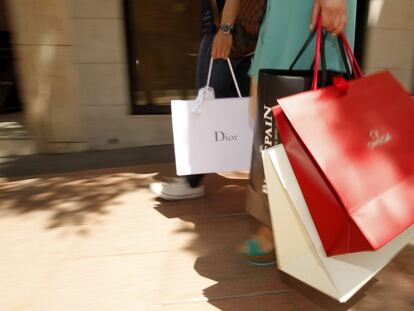 Dos turistas con bolsas de marcas de lujo en Madrid.