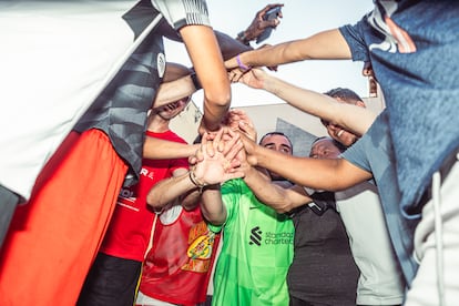 Los jugadores de los Dragones de Lavapiés entonan el nombre de su equipo en una piña tras el entrenamiento.