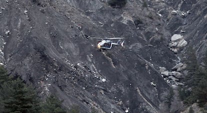 A helicopter flies over the area where the Germanwings flight crashed in Seyne, in the French Alps.