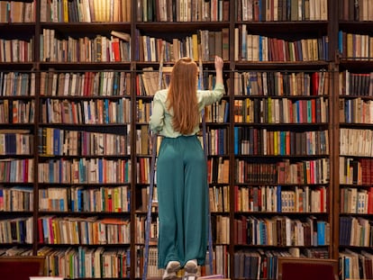 Una mujer en una librería observa cientos de libros.