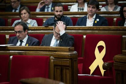 Jordi Turull en su asiento antes de su discurso de investidura, junto a un asiento vacío con un lazo amarillo en recuerdo a los diputados independentistas encarcelados.