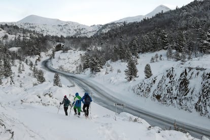 Varias personas con raquetas de nieve comienzan una pequeña travesía por el pirineo navarro, en la zona de Larra-Belagua, este domingo.