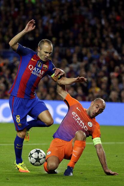 El centrocampista del FC Barcelona Andrés Iniesta (i) lucha por el balón con el defensa argentino Pablo Zabaleta, del Manchester City.