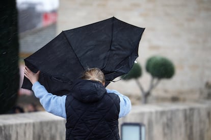 Una mujer intenta sujetar su paraguas mientras camina por el casco histórico de Córdoba, el pasado 19 de enero, durante el paso de la borrasca 'Juan'.