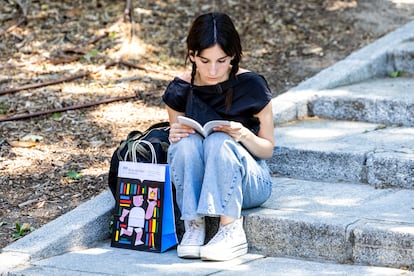 Una chica lee un libro en unas escaleras del parque de El Retiro.