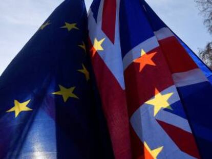 Banderas de la UE y de Reino Unido con el Parlamento británico de fondo. 