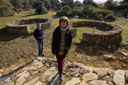 La antropóloga María Sánchez y el ecologista Juan Terroba, promotores del centro, posan ante el poblado neolítico compuesto por 15 chozas.