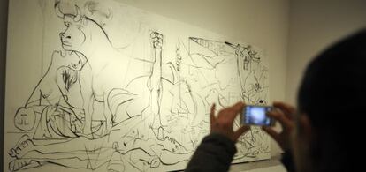 Un hombre fotografía una de las obras de la instalación sobre el 'Guernica' de José Ramón Amondarain en el Artium.