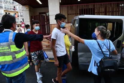 Trabajadores sociales dirigen a tres de los menores marroquíes a las puertas del juzgado este martes en Ceuta.