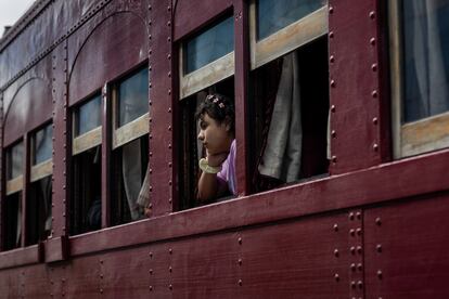 Una niña mira por la ventana desde el tren.