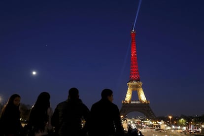 La Torre Eiffel iluminada con los colores de la bandera belga, en París (Francia).