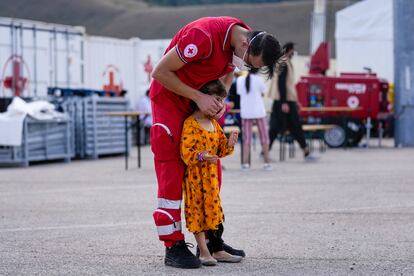 Un trabajador de Cruz Roja con un niño afgano en un campo de refugiados en Avezzano, Italia, el 31 de agosto.