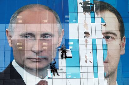 Dos trabajadores pegan un póster preelectoral con el rostro de Dmitri Medvédev y Vladímir Putin en un edificio de oficinas en la ciudad sureña de Krasnodar (Rusia), el 24 de noviembre de 2011. Con las distintas modificaciones, Putin, de 67 años, que lleva en el poder desde hace dos décadas, se aseguraría que nadie ostente el poder durante tanto tiempo como él. Es la persona que más tiempo ha estado al cargo desde Josef Stalin (en la URSS).