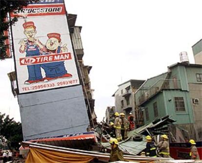 Los bomberos observan los desperfectos de un edificio de cinco plantas dañado por el terremoto.