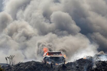 El humo provocado por automóviles en llamas durante un incendio en una parcela cubre el cielo en Tegucigalpa (Honduras).