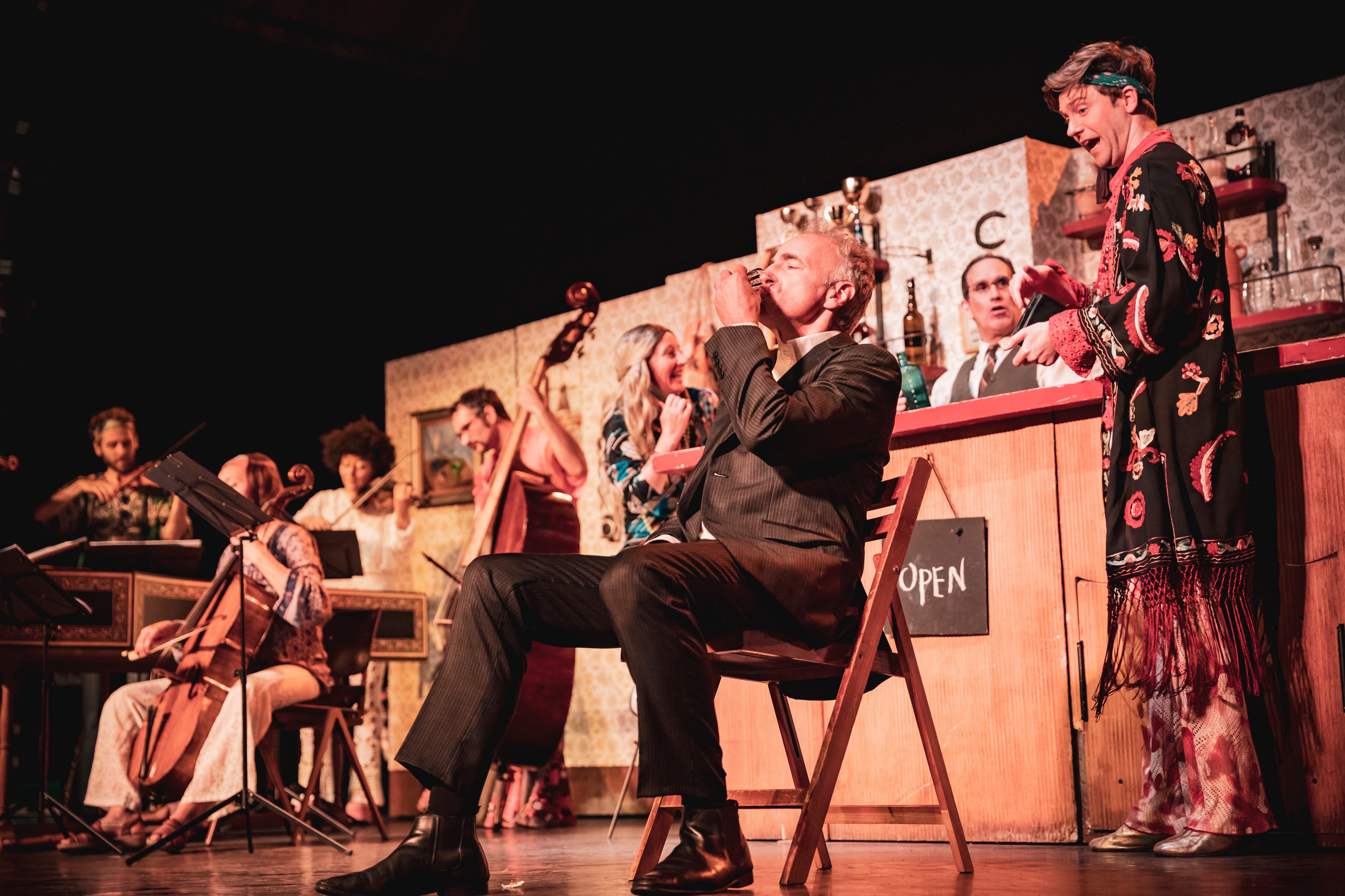 Versión escenificada de la 'Cantata del café' de Bach. En primer plano, el padre (Dietrich Henschel), bebiendo una taza de café, y detrás su hijo (Philipp Mathmann). Detrás de la barra, Adrian Schvarzstein, el director del espectáculo.