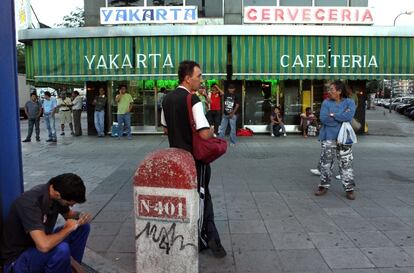 Muchos hombres se sientan a la puerta del bar a aguardar a su <i>pistolero</i>, otros desayunan tranquilamente hasta que les recojan para ir a la obra.