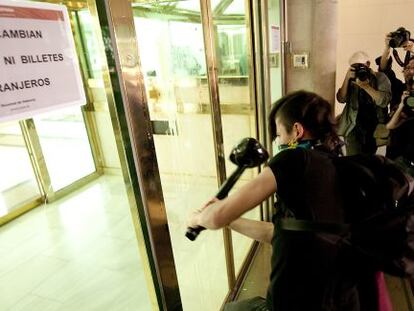 Un manifestante golpea la puerta del Banco de Espa&ntilde;a en un momento del recorrido.
