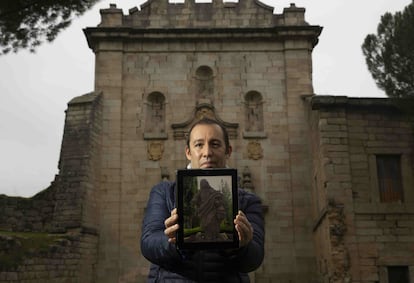 Mario Cuéllar delante del pórtico del Monasterio de Santa Maria la Real de Valdeiglesias, con la foto de la escultura que ha localizado en una finca en Toledo.