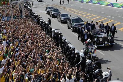 Flanqueado por la primera dama Michelle Bolsonaro, el presidente de Brasil, saluda a la multitud mientras viaja en un automóvil abierto después de su ceremonia de jura del cargo, en Brasilia.