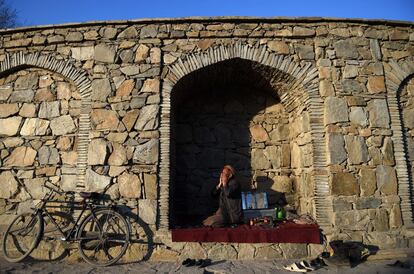Un zapatero afgano durante la oración en Kabul (Afganistán).
