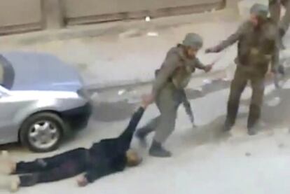 Una captura de un vídeo que muestra a un militar sirio arrastrando el cuerpo de un civil en una calle de Damasco.