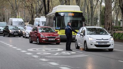 Un Policía Municipal durante un control de tráfico por el coronavirus en el Paseo del Prado, este domingo.