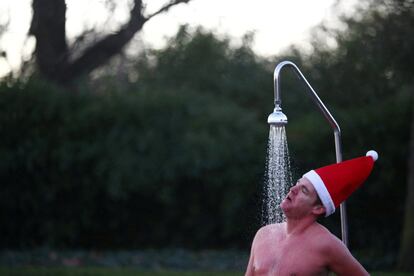 Un nadador con gorro de Papá Noel se ducha el día de Navidad en el lago Serpentine en Hyde Park, en Londres (Reino Unido). Las autoridades de Japón anunciaron que han detectado por primera vez varios casos de la nueva cepa de coronavirus que portaban viajeros que llegaron al país procedentes del Reino Unido.