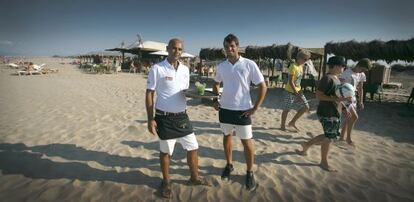 Clientes y camareros ante el chiringuito Oli-ba-ba, en la playa de Oliva.