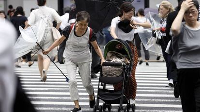 Pessoas lutam contra os fortes ventos e a chuva em Tóquio.