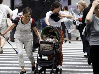 Pessoas lutam contra os fortes ventos e a chuva em Tóquio.