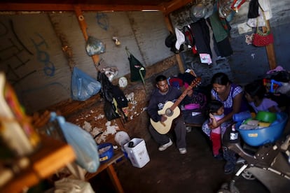 A fruit picker plays guitar to his family inside their house in San Quintin, Baja California state, Mexico March 31, 2015. Fruit pickers in the Baja California peninsula of Mexico, railing against a life of grinding poverty, have blocked roads, staged marches and held meetings with lawmakers since March as frustration over working conditions boiled over. One labourer in San Quintin, south of the border town of Tijuana, sleeps with his family on the bare earth in a tiny wooden shack on scrubland. He said after picking between 110 kg and 200kg of strawberries a day he earns from $56 to $79 a week. Strawberries fetched $5.19 a kilo on average in the United States in 2013. REUTERS/Edgard Garrido  PICTURE 5 OF 27 FOR WIDER IMAGE STORY "FRUITS OF WRATH" SEARCH "GARRIDO WRATH" FOR ALL IMAGES