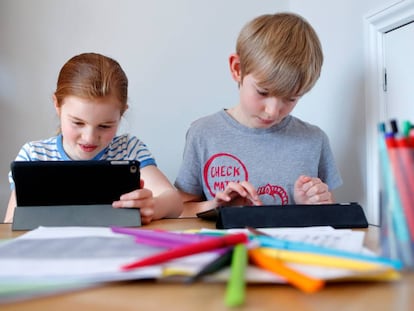 Dos niños realizan tareas escolares.