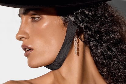 Sombrero de fieltro y algodón de LORO PIANA y pendientes B.zero1 en oro rosa con pavé de diamantes de BVLGARI.