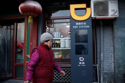 Una mujer pasa junto a una estación de DiDi, en Pekín. 