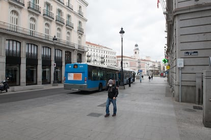 Una persona con mascarilla anda por la calle Calle Alcalá junto a la turística Puerta del Sol madrileña vacía durante el estado de alarma.