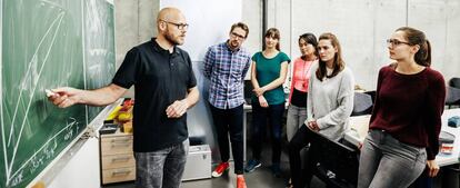 Un profesor imparte una clase a alumnos universitarios. 