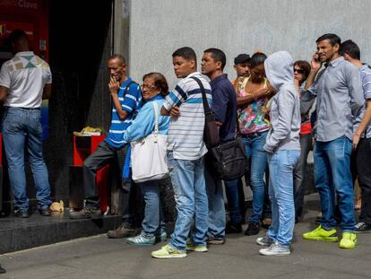 Venezolanos hacen cola para sacar dinero en Caracas, este jueves.