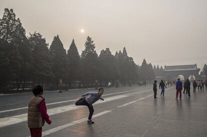 Un hombre hace ejercicio frente a un templo en uno de los días más contaminates en Beijing, China.