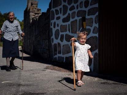 Una mujer de 95 años pasea junto a una de sus bisnietas en la aldea de San Xurxo (Ourense), el pasado verano.