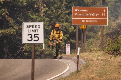 Un bombero camina por la carretera mientras luchan contra el incendio dentro del parque nacional Yosemite, el 11 de julio de 2022.