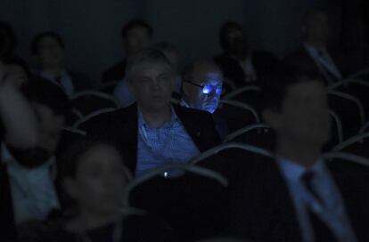 Un hombre del público es iluminado por su teléfono móvil durante la Cumbre Mundial de Transporte Aéreo, celebrada en Dublín, Irlanda.