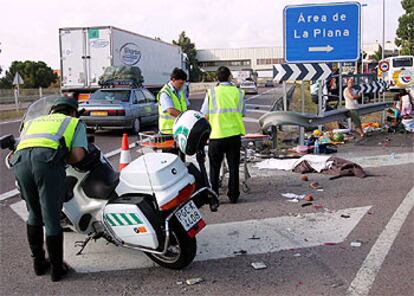 Agentes de la Guardia Civil, ayer, junto al cadáver de la víctima del siniestro en la autopista AP-7 en Burriana.